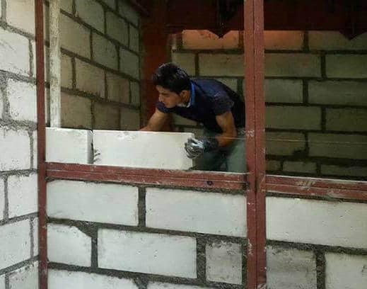 کارگر ساختمان در حال بهینه سازی انرژی با وال پست